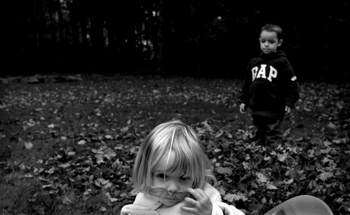 First Place, Photographer of the Year - Dale Omori / The Plain DealerMargaux plays in leaves with Henri.  Margaux, 2, stands in front of her brothers when they ignore her and demands their response.  "Answer me," she says.  Margaux does not suffer from autism like her three older brothers.