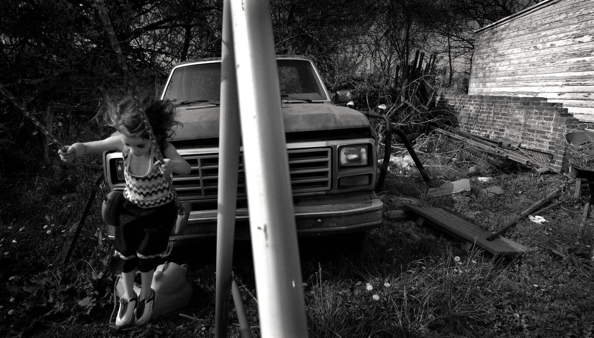 First Place, Photographer of the Year - Dale Omori / The Plain DealerA vacant lot strewn with firewood and an aging truck, and near a busy rail line, serves as a playground for Tabitha Martin. She is one of thousands of children who live and play in the shadows of abandoned factories and waste sites in Cleveland's Kinsman neighborhood.