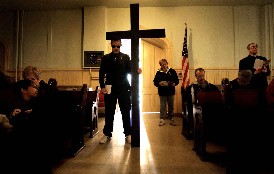 First Place, Photographer of the Year - Dale Omori / The Plain DealerSteve Grajewski, of Brooklyn, holds the cross in Zion United Church of Christ April 18, 2003.  Grajewski was one of several people praying the stations of the cross.  The ecumenical procession stopped at various Tremont churches in observance of Good Friday.  Zion United Church of Christ was the first stop. 