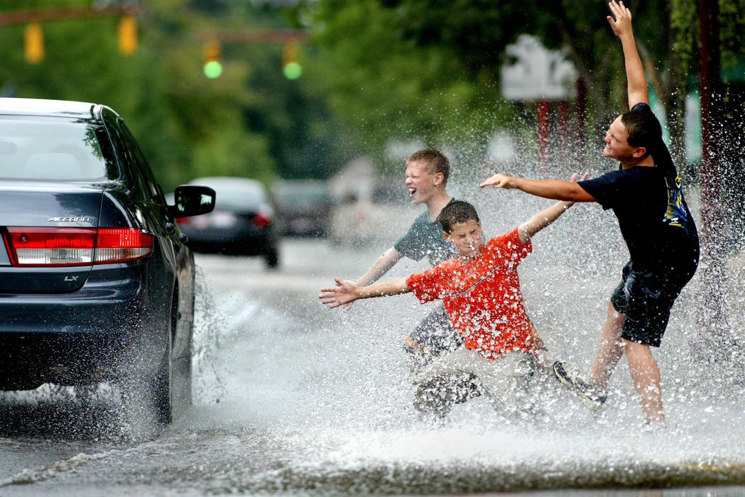 Third Place, Photographer of the Year - Fred Squillante / The Columbus DispatchFrom left to right: Dillon Hoopes, 11; Zach Cihon, 11; and Ryan Grove, 11, all of Hilliard found many obliging drivers when they indicated they wanted to be splashed on Main St. in Hilliard.  They came to Main St. and rode their bikes through the flooded street in the morning. They were waving to passing cars trying to get the cars to drive close enough to splash them. Many drivers did. 