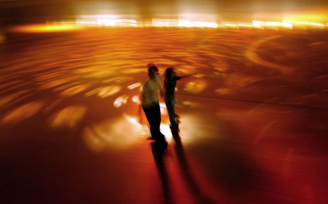 First Place, Photographer of the Year - Dale Omori / The Plain DealerTwo girls roller skate through the swirling lights at Skate World Roller Skating Center in Lorain, Mar. 15, 2003.  