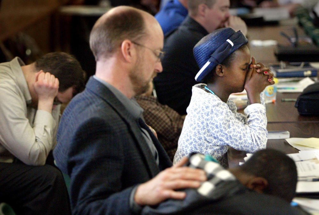 Third Place, Photographer of the Year - Fred Squillante / The Columbus DispatchJim Baden, second from left, prays with Wasihun, bottom, and Agernesh, in hat, at their first church service together.