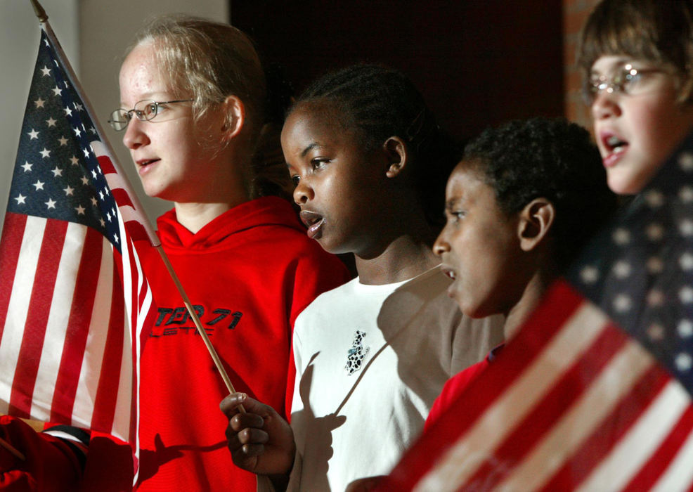 Third Place, Photographer of the Year - Fred Squillante / The Columbus DispatchAgernesh, holding flag, and Wasihun join Jamie Hamilton, left, and Julia Nixon, right, in singing God Bless the USA at the Johnstown Home School.