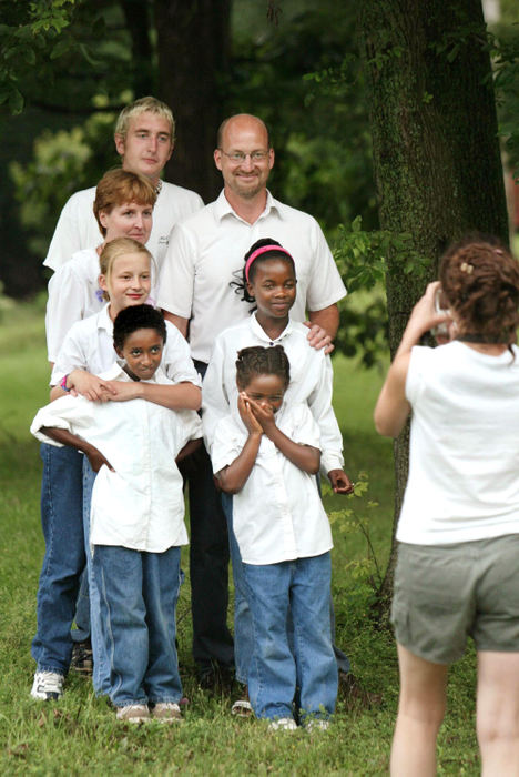 Third Place, Photographer of the Year - Fred Squillante / The Columbus DispatchKristian, hands to face, giggles as family friend Amber Walsh  takes a family portrait. Clockwise, from bottom left, are: Wasihun, Caroline, Robyn, Adam, Jim, Agernesh and Kristian.