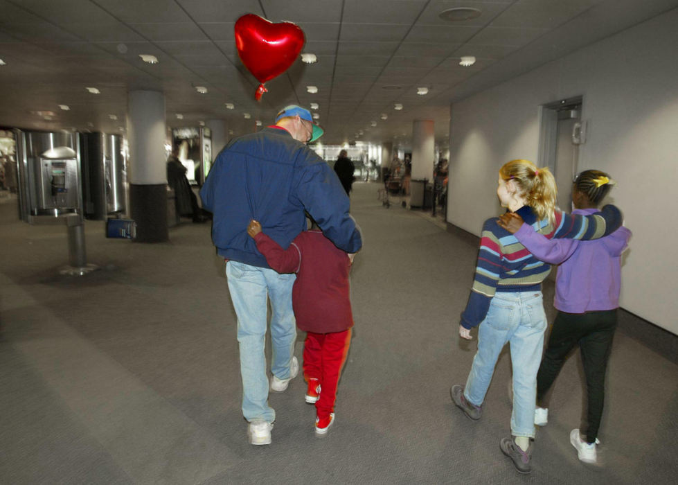 Third Place, Photographer of the Year - Fred Squillante / The Columbus DispatchArm in arm, members of the newly enlarged Baden family leave the airport in February. The latest additions to the Baden family face monumental adjustments, but with love and patience, their new family is embracing them.