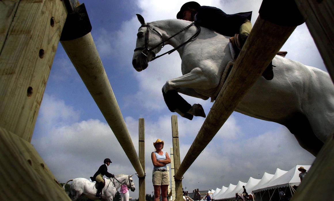 First Place, Photographer of the Year - Dale Omori / The Plain DealerTrainer Emily Elek, of Ixonia, WI, yells out encouragement to rider Haylie Lundin, 11, of Cherry Valley, IL, as she warms up for the Stateline Tack/USAE National Pony Finals Aug. 8, 2003, Willloughby.  Lundin was preparing for the Medium Pony Hunters competition.  