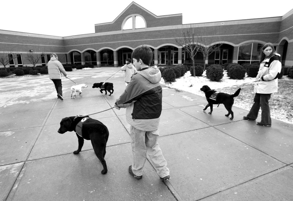 Third Place, Photographer of the Year - Fred Squillante / The Columbus DispatchZach Farris, center foreground holding Frasier, joins other members of his class as they arrive at Westerville North High School. At right is one of his teachers, Amy DuBois, holding Falcon. This is one of their Friday excursions in which the Kids and Canines group take the dogs out in public. The kids made presentations to high school students. 