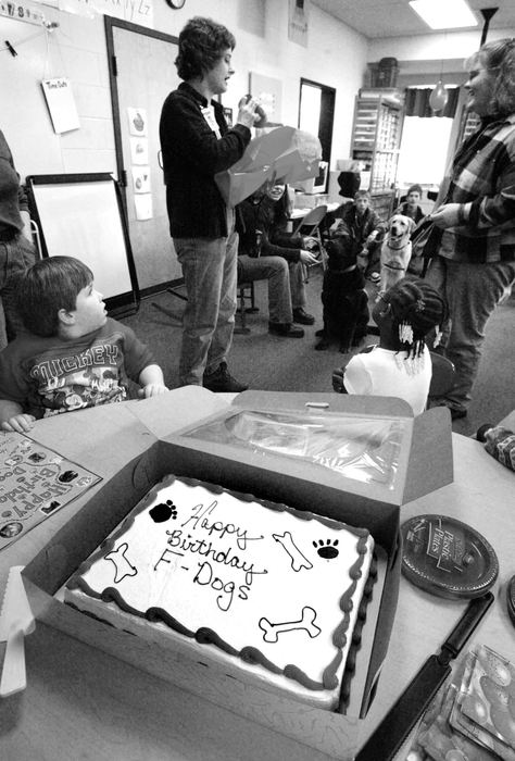 Third Place, Photographer of the Year - Fred Squillante / The Columbus DispatchLea Ann Shearer of Golden Dogs Academy opens presents from Shelli Speakman's multiple handicaps class at Alcott Elementary School. The Kids and Canines participants visited the school and  celebrated the two-year anniversary of Kids and Canines program. Lea Ann Shearer provides the dogs for the Kids and Canines program and teaches the students how to train the dogs.