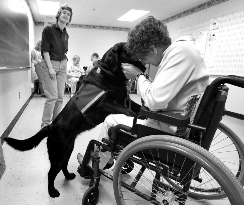 Third Place, Photographer of the Year - Fred Squillante / The Columbus DispatchLea Ann Shearer, left, of Golden Dogs Academy, observes Elsie Danevich with her new service dog, Fonda, that was trained by students in the Kids and Canines program. 