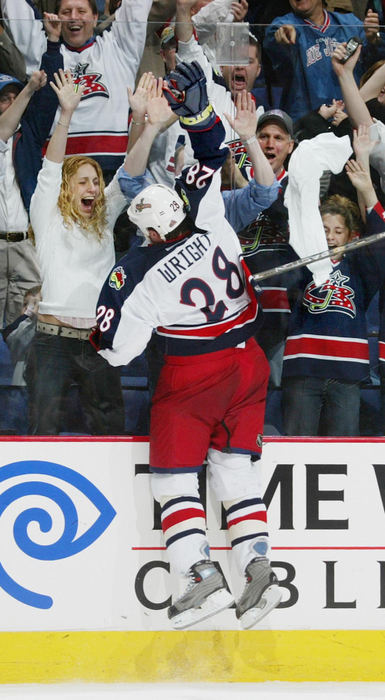 Award of Excellence, Sports Feature - Neal C. Lauron / The Columbus DispatchColumbus Blue Jackets Tyler Wright, 28, jumps up in celebration to high five adoring fans through the glass after scoring a hat trick during overtime against the Toronto Maple Leafs at the Nationwide Arena.