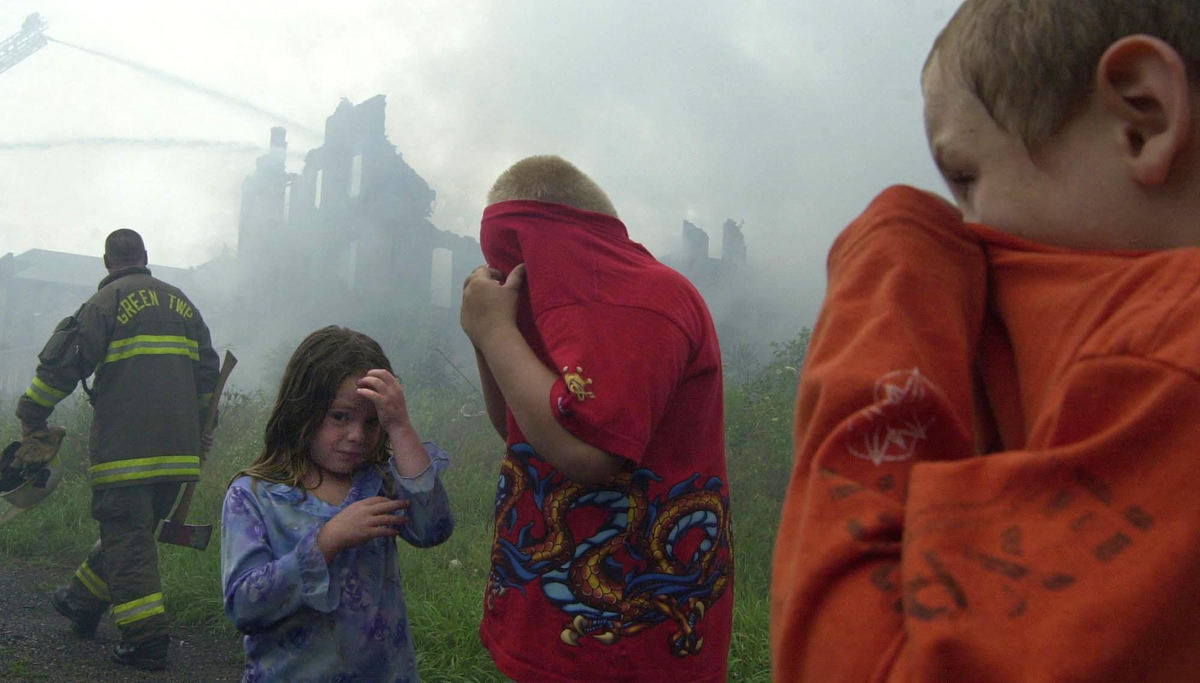 Second Place, Spot News under 100,000 - Aaron Rudolph / The Morning JournalAlexa Mason, (from left), Coty Heveroy and Joseph Smith cover their mouths and eyes as the old Salem China Co. burns.