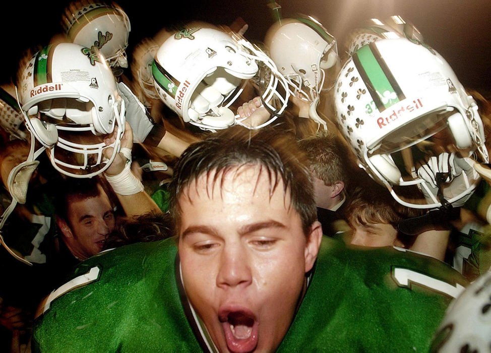 First Place, Student Photographer of the Year - Haraz Ghanbari / Kent State UniversityDublin Coffman's Donnie Reinhart, center, celebrates with his teammates after their 31-22 win over Marion Harding, Oct. 31, 2003 in Dublin. 