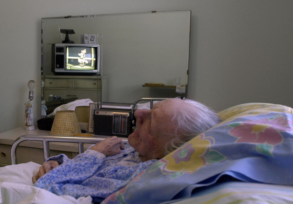 First Place, Student Photographer of the Year - Haraz Ghanbari / Kent State UniversityEvelyn Shaw sits in bed while cartoons play on a television, Dec. 27, 2003 in her North Rideville home. Evelyn was diagnosed with Alzheimer's Disease in 1992 and has been confined to a bed since 1994. She has lost her ability to speak and moves very little. She communicates with her husband by smiles and an occasional wink.  