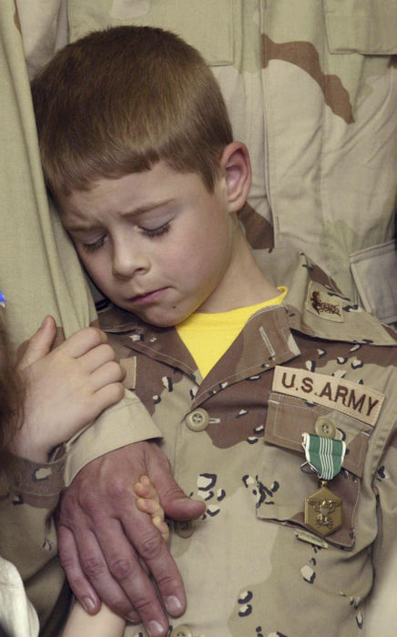 Second Place, Student Photographer of the Year - Scott R. Galvin / Kent State UniversityZachary Wack, 7 of Lordstown, holds his father's arm, Capt. Chuck Wack, 36, during the award presentation to the 423d Quartermaster Battalion at the Lordstown Fire Station  May 31, 2003. He is also wearing his father's Amry Commendation Medal, which was presented to Chuck and other unit members for exemplary service.