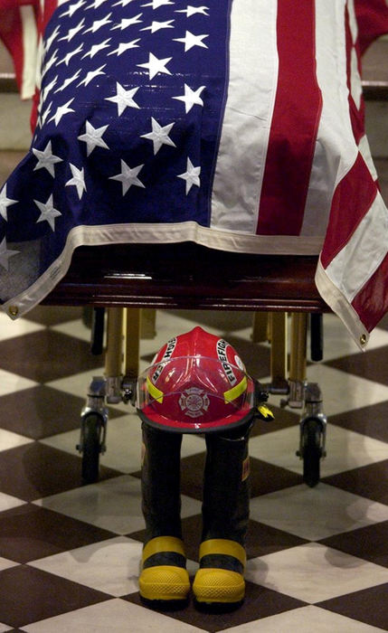 First Place, Team Picture Story - Michael Keating / Cincinnati EnquirerBoots and a helmet sit before Oscar Armstrong's casket during his funeral services at St. Xavier Church.