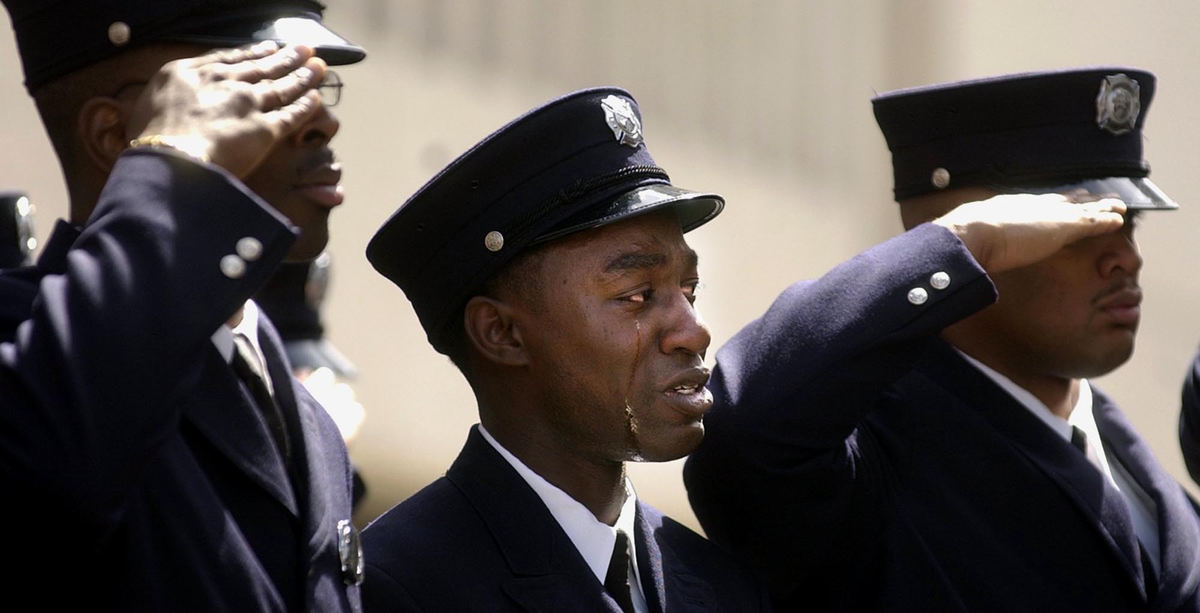 First Place, Team Picture Story - Michael Keating / Cincinnati EnquirerTears flow down the cheeks of a Cincinnati firefighter as Oscar Armstrong's casket passes by during his funeral. 