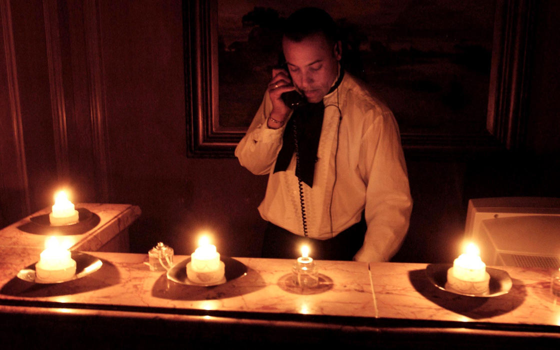 Second Place, Team Picture Story - Marvin Fong / The Plain DealerChet Walker, a guest services worker at The Ritz-Carlton Hotel in downtown Cleveland, works by candlelight during the power outage.  