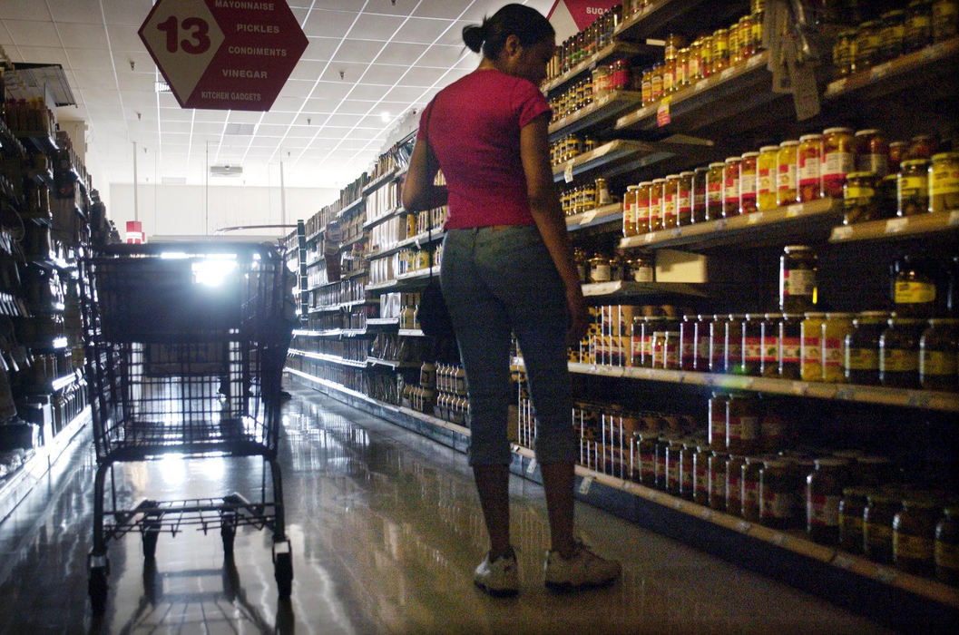 Second Place, Team Picture Story - Eustacio Humphrey / The Plain DealerCynthia Adams shops in the near darkness of a Tops supermarket following the power outage that affected up to 50 million people.  