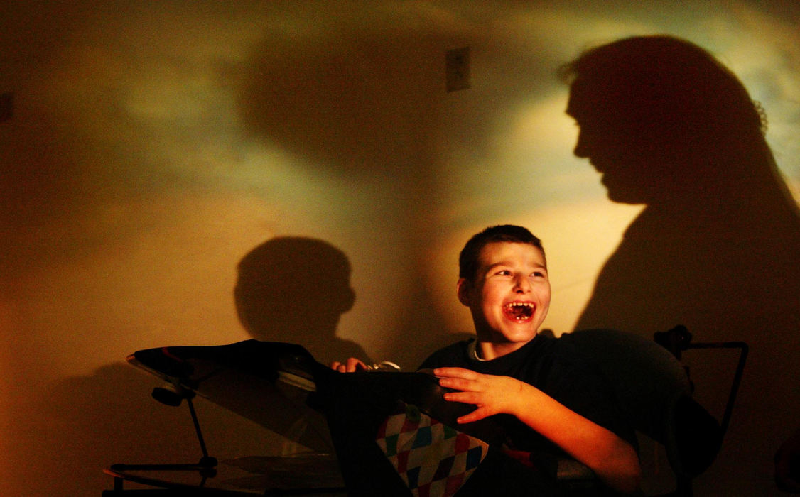 Award of Excellence, Assigned Feature - Chris Stewart / Dayton Daily NewsWith a revolving light casting projections and their shadows, Marcus "Dillon" Bertrand, 11, works with occupational therapist Sharon Mullins in the "Snoezelen," a room built for sensory stimulation and relaxation at the Stillwater Center. The home which replaced an antiquated former TB hospital can care for 98 full-time residents with profound mental disabilities and others needing respite care.