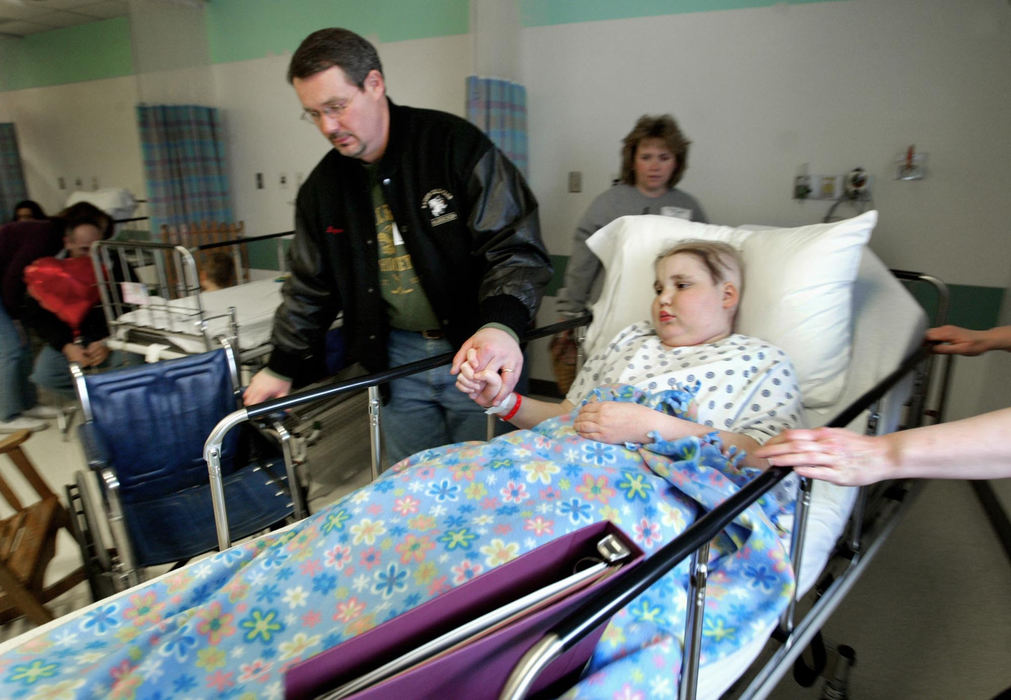 Second Place, Feature Picture Story - Fred Squillante / The Columbus DispatchAbbie holds onto her father Larry's hand  as she is taken to surgery to have a spinal tap. 