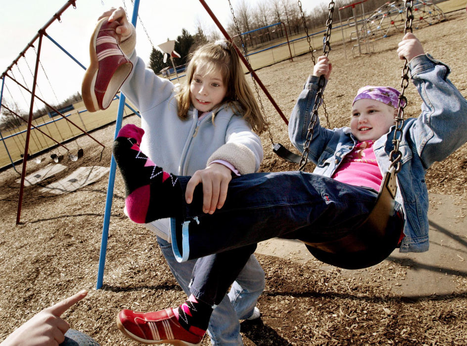Second Place, Feature Picture Story - Fred Squillante / The Columbus DispatchFriend Ellen  Leslie tries to put Abbie's shoe back on as Abbie swings at her school.
