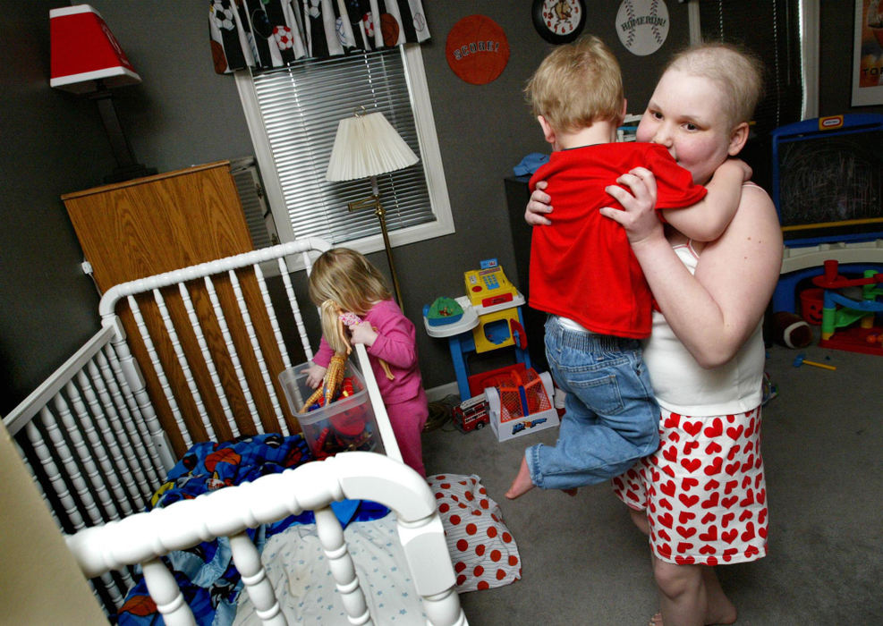 Second Place, Feature Picture Story - Fred Squillante / The Columbus DispatchAbbie takes her brother Luke out of his crib after he awoke from a nap. At left is her little sister Leanna. 