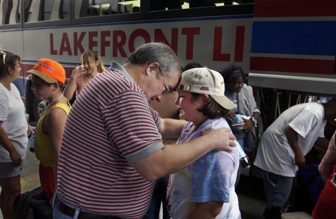 First Place, Feature Picture Story - Gus Chan / The Plain DealerIt would be all too easy for young burn victims to live life in the shadows.  Burn Camp helps them build confidence to face the world. Mallory Horne, 10, gets reacquainted with her father, Larry, after the bus arrived at MetroHealth from Camp Christopher, August 29, 2004. 