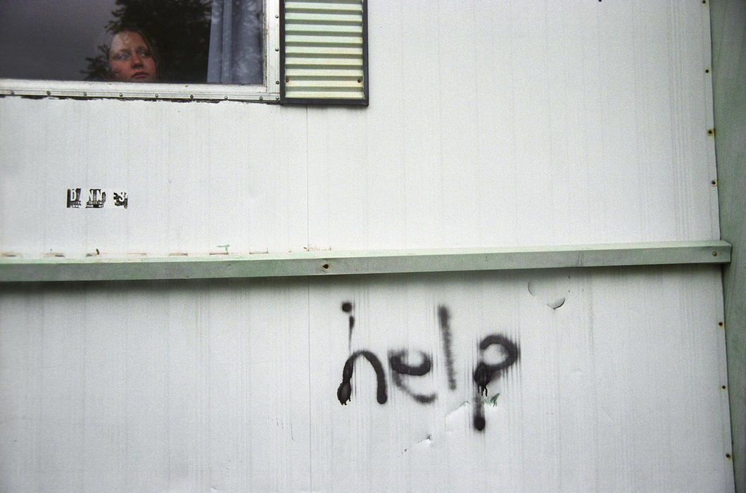 Third Place, Feature Picture Story - Samantha Reinders / Ohio UniversitySpray-painted in thick black letters onto the wall of a trailer the word ‘HELP’ greets you has you enter Pine-Aire Village. This is the story of Brittany, Anthony, Chris, Andy, Sonya, Christine and Elijah - just some of the children of Pine-Aire Village. Christine watches her brothers outside her home.