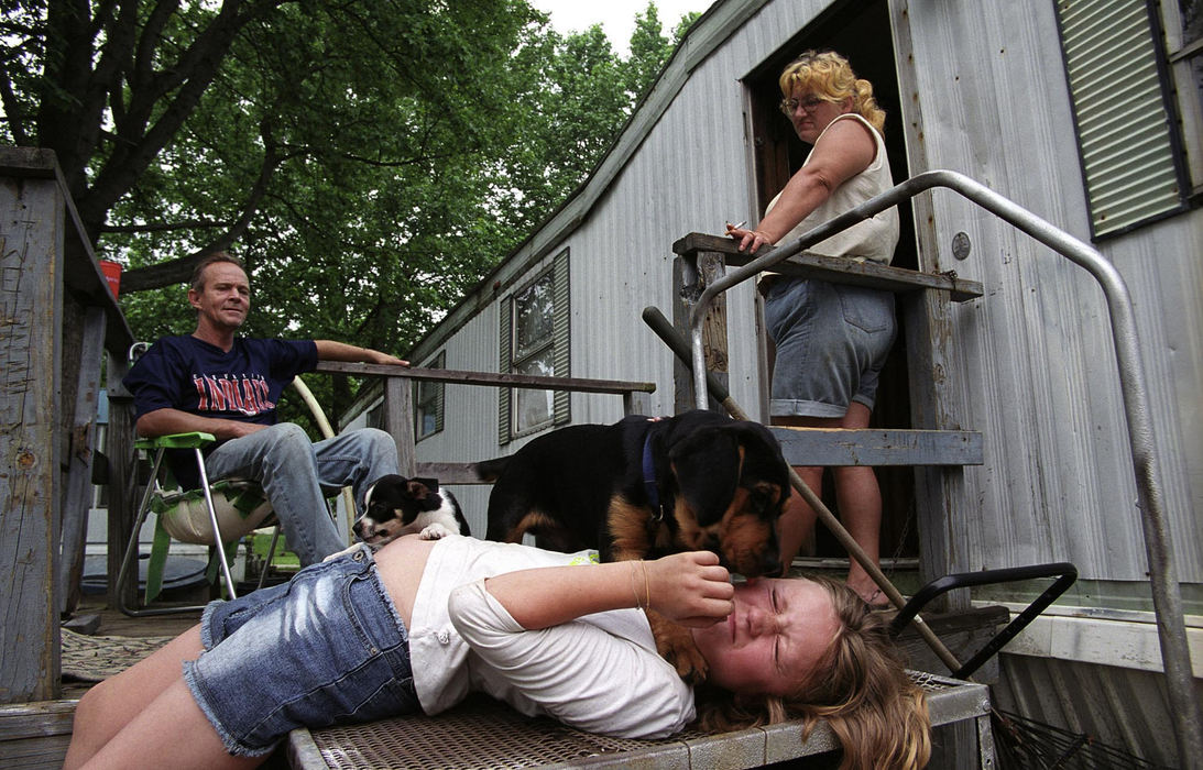 Third Place, Feature Picture Story - Samantha Reinders / Ohio UniversityIt is a weekday afternoon and Christine’s jobless mother and stepfather look on as George – a stray dog that has made his home with the family – attacks her with licks. 