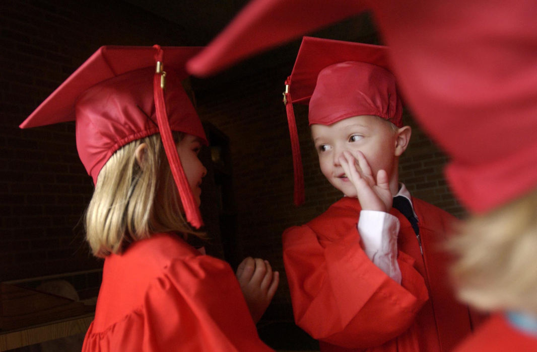 Award of Excellence, Feature Picture Story - Gus Chan / The Plain DealerAlex Vertosnik (right) talks with classmate Cassie Carlo before the kindergarten graduation at St. Christine, June 2, 2004.  St. Christine School closed it's doors for good after the school year. 