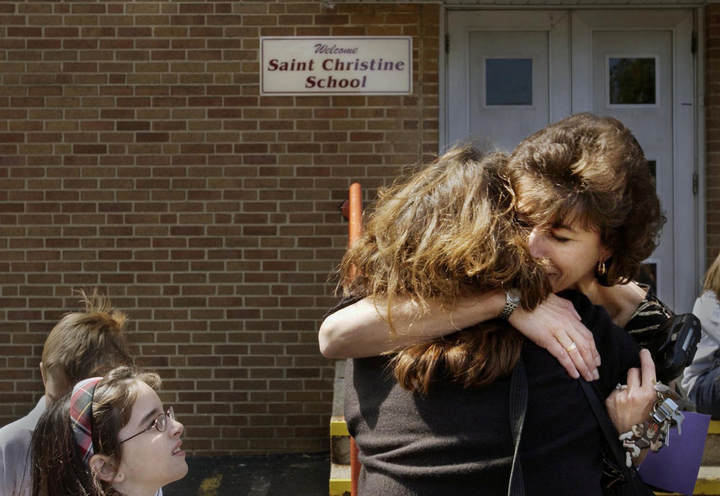 Award of Excellence, Feature Picture Story - Gus Chan / The Plain DealerSusan Johnson gets a hug from Anne Marie Fiorello on the last day of school for St. Christine School, June 4, 2004.  St. Christine closed their doors for good at the end of the school year.