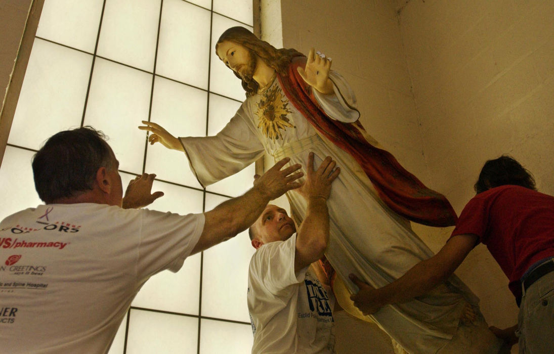 Award of Excellence, Feature Picture Story - Gus Chan / The Plain DealerDan Kever, custodian at St. Christine School, lowers the statue of Jesus from it's perch, June 10, 2004.  The school officially closed on June 4, 2004, but school staff stayed on to pack up classrooms and sell off the remainder of the school items. 