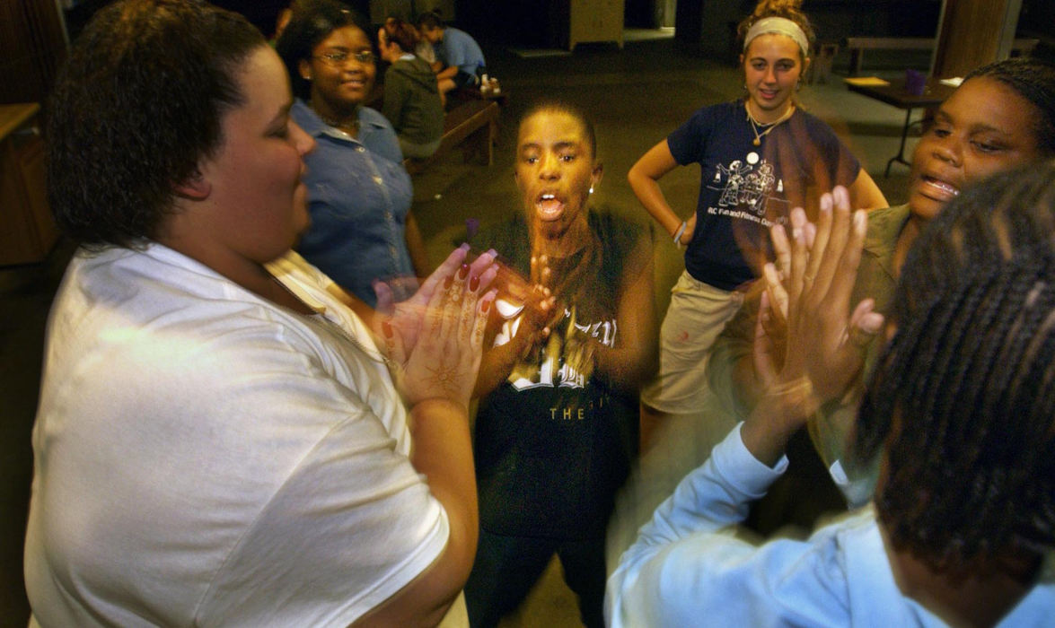 First Place, Feature Picture Story - Gus Chan / The Plain DealerHerbie Jones joins in a four person clapping game during a rainy night, August 28, 2004, at Camp Christopher.  