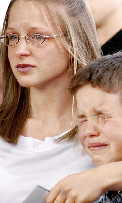 Second Place, News Picture Story - Daniel Melograna / The News JournalAshley Phelps comforts Cody Loveland as he begins to cry, April 17, 2004, as members of the 16th Calvary Division from Fort Knox, Ky., carry the body of A.J. Vandayburg out of Finefrock-Williams Funeral Home in Mansfield.  Vandayburg, who was in the 1st Infantry Division in the U.S. Army, died from combat injuries on April 8, 2004, in Barez, Iraq. 