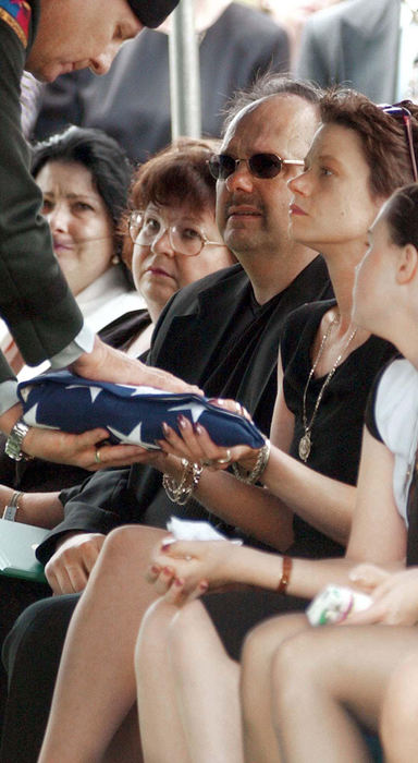 Second Place, News Picture Story - Daniel Melograna / The News JournalU.S. Brigadier General Roger Nadeau hands the American flag that was draped over Allen Jeffrey Vandayburg's coffin to Chantil Vandayburg on, April 17, 2004, at the end of the funeral precession at the Mansfield Cemetery. A.J. Vandayburg, who was in the 1st Infantry Division in the U.S. Army, died from combat injuries on April 8, 2004, in Barez, Iraq. 