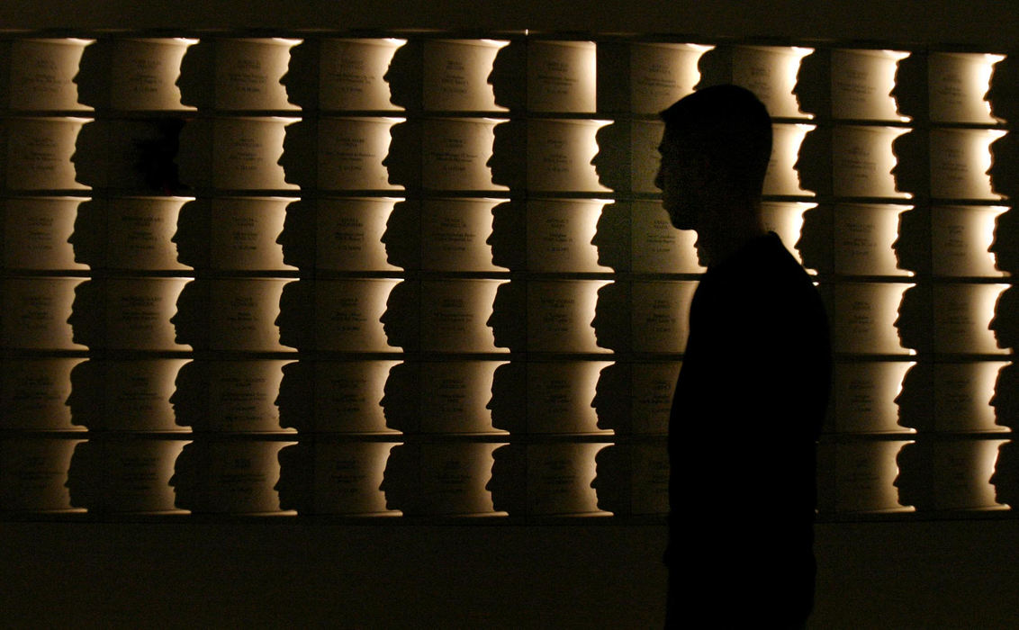 Second Place, Pictorial - Michael P. King / Ohio UniversityOld Bridge, N.J. resident Alex Hamburger walks past a memorial constructed in Staten Island, N.Y. honoring the victims of the September 11, 2001 World Trade Center attack. The memorial, entitled "Postcards", has two walls 37 feet tall containing profiles of some 267 Staten Island residents who perished in the terrorist attack. Each crafted profile is unique and accurate to the victim it memorializes.