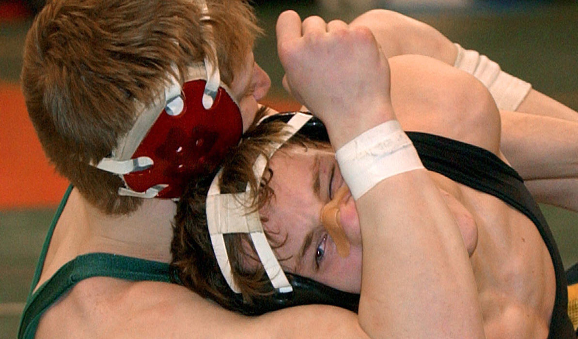 First Place, Photographer of the Year - John Kuntz / The Plain DealerJosh Rohler (left) from St. Vincent-St. Mary squeezes the face of his opponent Lucas Ransbottom from St. Paris Graham in their 140lb. Division II match February 26, 2004 during the Ohio High School Athletic Association's 67th state wrestling championship at the Jerome Schottenstein Center in Columbus.  Josh won his match 7-1.