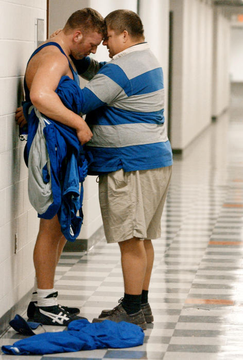 First Place, Photographer of the Year - John Kuntz / The Plain DealerBen Doolittle a senior at Gallipolis Galia Academy is comforted by his coach Todd May (R) after a defeat in the quarterfinal consolation round that ends his days as a high school wrestler February 27, 2004 during the 67th OHSAA state wrestling championship in Columbus.
