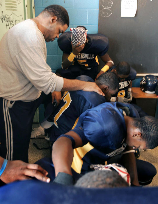 First Place, Photographer of the Year - John Kuntz / The Plain DealerChip bows his head in prayer with the rest of the Warrensville Heights High School football team before a game where he is an assistant coach.