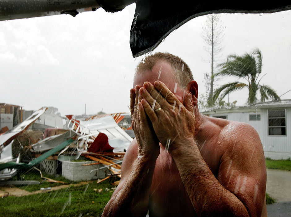 Second Place, Photographer of the Year - Mike Levy / The Plain DealerDean Herbert whose mobile home was destroyed at River Haven mobile home park in Punta Gorda, Florida due to Hurricane Charley takes advantage of an afternoon thunderstorm and uses the rain water to bath..  