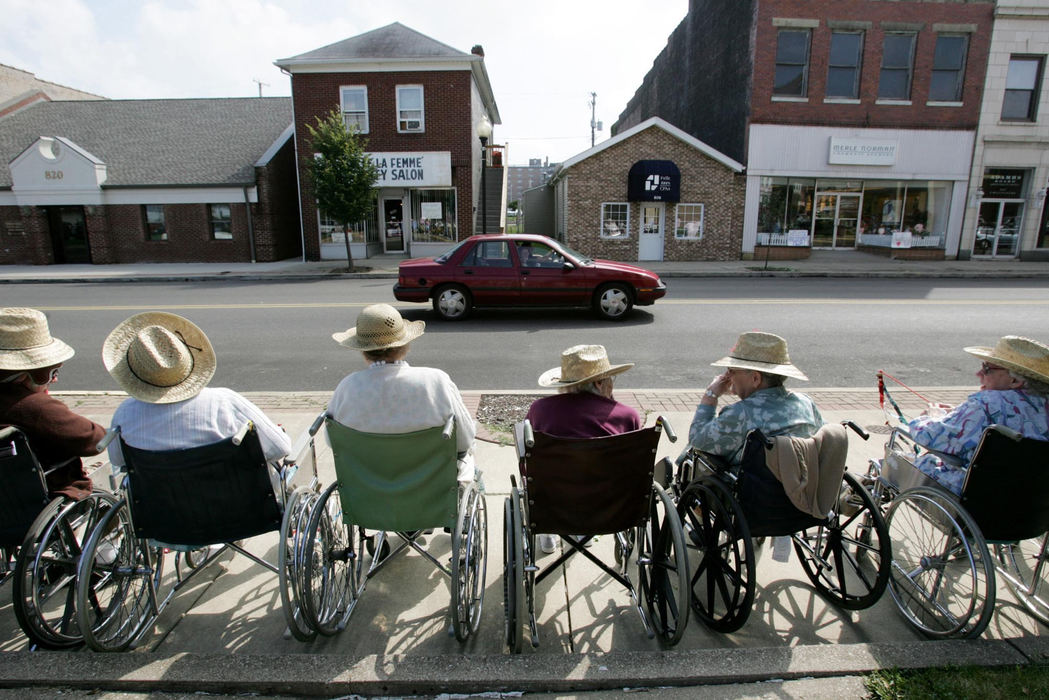 Award of Excellence, Photographer of the Year - Fred Squillante / The Columbus DispatchResidents of Hempstead Manor wait for President George Bush's motorcade to arrive in downtown Portsmouth for a campaign stop. The residents staked out their spots early; some had to retreat under shade trees and umbrellas due to the heat. Ohio was a key state in the 2004 election, and both presidential candidates made numerous trips to the state.