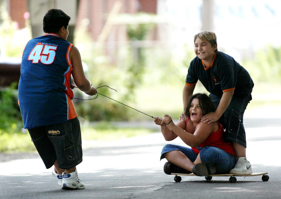 Award of Excellence, Photographer of the Year - Fred Squillante / The Columbus DispatchDonavon Gavina, 11, left, pulls his brother Carlos Gavina , 9, and friend Rebecca Adamson, 9, on one of the two contraptions they all had a hand in building. Looking out for cars, they played on a street in front of their New Rome, Ohio, homes. They said this board with wheels originally had a seat belt, but it fell off.