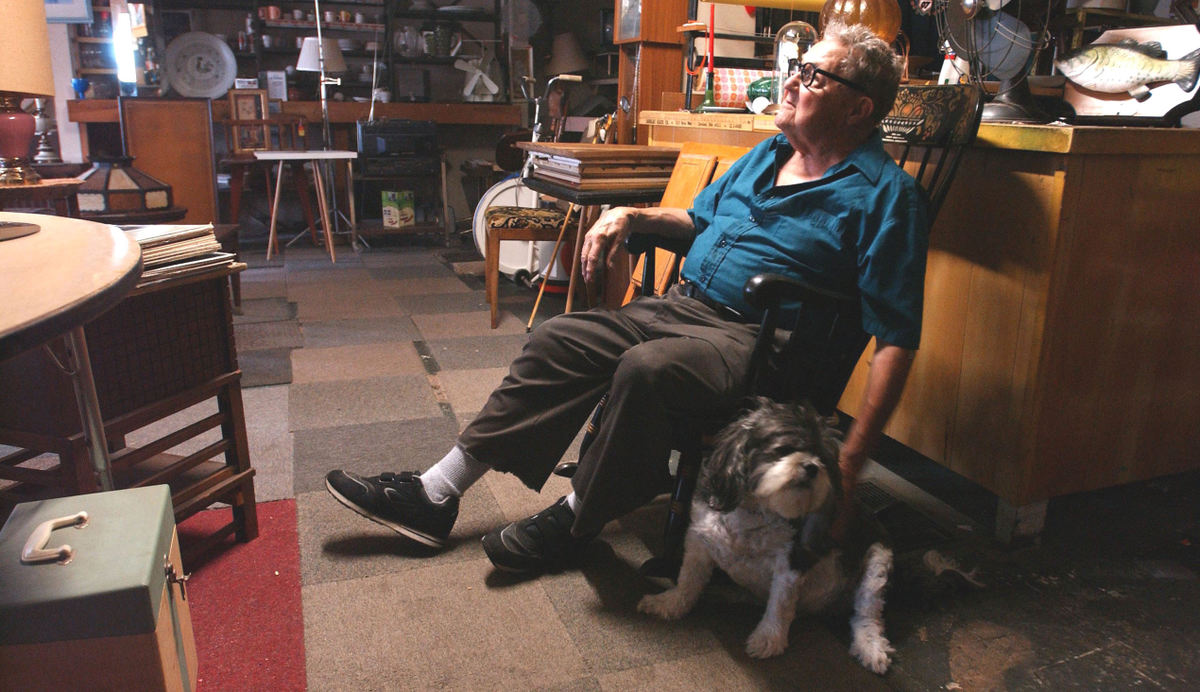 First Place, Portrait/Personality - C.H. Pete Copeland / The Plain DealerEugene Maher 88, and his dog wait for customers in his shop on Euclid Ave. Maher started the business for his wife before she past away.  He now waits daily in near darkness for anyone to enter to buy or just talk.