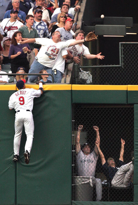 Award of Excellence, Sports Action - Chuck Crow / The Plain DealerCleveland Indians right fielder Jody Gerut watches the home run ball hit by the Yankees' Tony Clark  fall just out of reach of some fans in the 2nd inning.  New York Yankee bullpen players celebrate the homer on the right, giving the Yankees a 3-0 lead. 