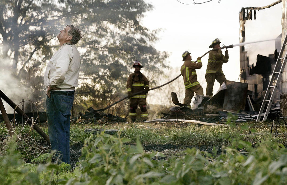 Second Place, Spot News over 100,000 - Neal C. Lauron / The Columbus DispatchJohn Timmons of Lockbourne reacts as firefighters from Harrison, Scioto and Jackson Townships put the fire out of his home, October 7, 2004. Timmons threw ashes from his wood burning stove on to the grass and went into his home to take a nap, the ash caught the grass on fire, his house and was fully engulfed by flames before he realized and escaped with the clothes on his back and shoeless. He had no fire insurance and farms the area.