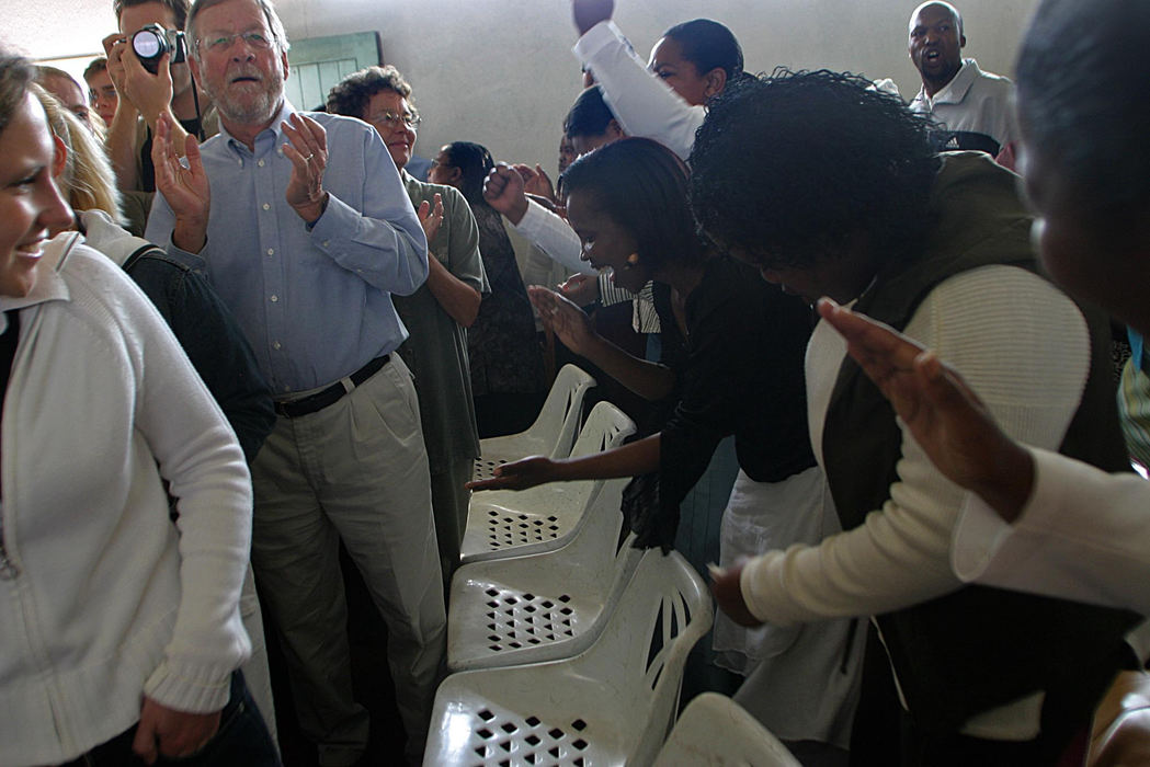 First Place, Student Photographer of the Year - Samantha Reinders / Ohio UniversityThe Religion Factor - Brad and Melissa Holmes (Australian) and visiting medical students from Germany are mesmerized by a Moravian church service in Gugulethu Township. Different tour companies use assorted adjectives to market their tours. Brochures describe “Freedom” tours, “Cultural” tours, “Vibrant “ tours and even “Gospel” tours. Churches in the townships welcome tourists who are treated as celebrities and whose donations enable them to keep their doors open. 