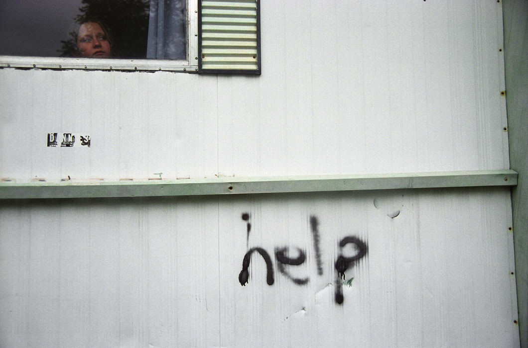 First Place, Student Photographer of the Year - Samantha Reinders / Ohio University Spray-painted in thick black letters onto the wall of a trailer the word ‘HELP’ greets you has you enter Pine-Aire Village. The high school drop out rate in Appalachian Ohio is three times the national average, drug and alcohol abuse are rampant in this trailer park and physical and mental abuse are daily occurrences on its streets. This is the story of Brittany, Anthony, Chris, Andy, Sonya, Christine and Elijah - just some of the children of Pine-Aire Village.  Christine watches her brothers outside her home.