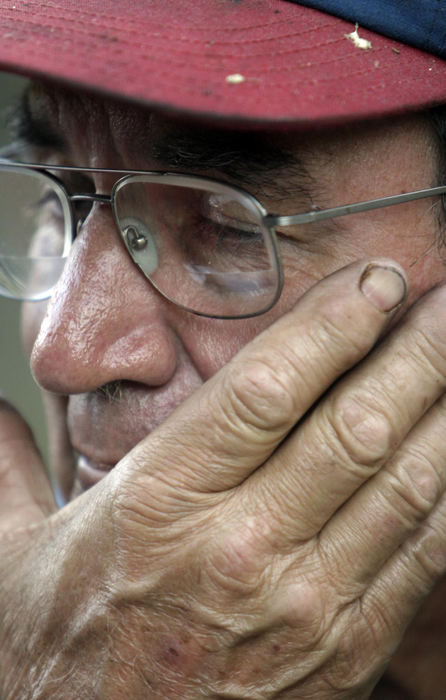 Second Place, Student Photographer of the Year - Michael P. King / Ohio UniversityJohn Schwarzel, owner of Schwarzel Marine on State Route OH-124, tiredly wipes his face during a long day of flood cleanup at his shop on September 30, 2004. Schwarzel, who has lived in Hockingport and run his business since the mid-1960s, said that he's never seen such a flood. $1 Million-worth of Schwarzel's new and used boating motors were submerged or touched by the muddy floodwaters.