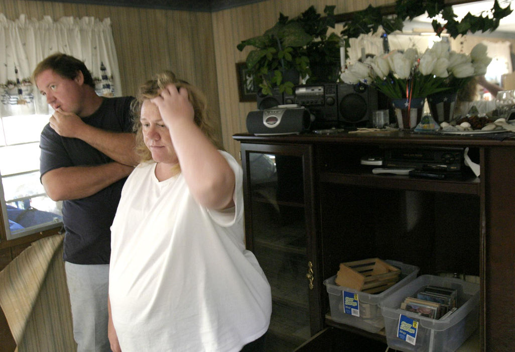 Second Place, Student Photographer of the Year - Michael P. King / Ohio UniversityBlaine Schwarzel and wife Amanda stand aside in their living room as an insurance adjuster takes measurements and accounts of the damage sustained to the Schwarzels' trailer on Pine Lane, Sunday, September 26, 2004. All of the furniture and carpeting were discarded, and even some of the children's toys floated-away down-river. The adjuster declared the dwelling totaled and the family soon began looking through catalogs for a new mobile home.