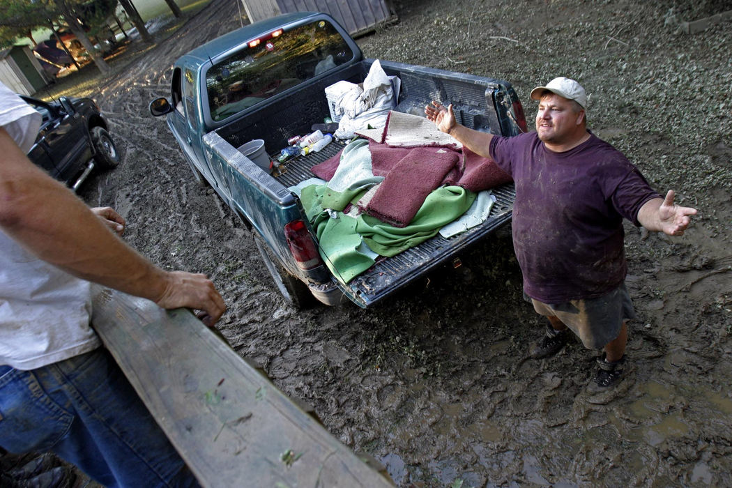 Second Place, Student Photographer of the Year - Michael P. King / Ohio UniversityTodd May, a friend of the Schwarzel family, tells a tall-tale while helping discard carpeting and other furnishings from Blaine and Amanda Schwarzel's trailer on September 22, 2003.